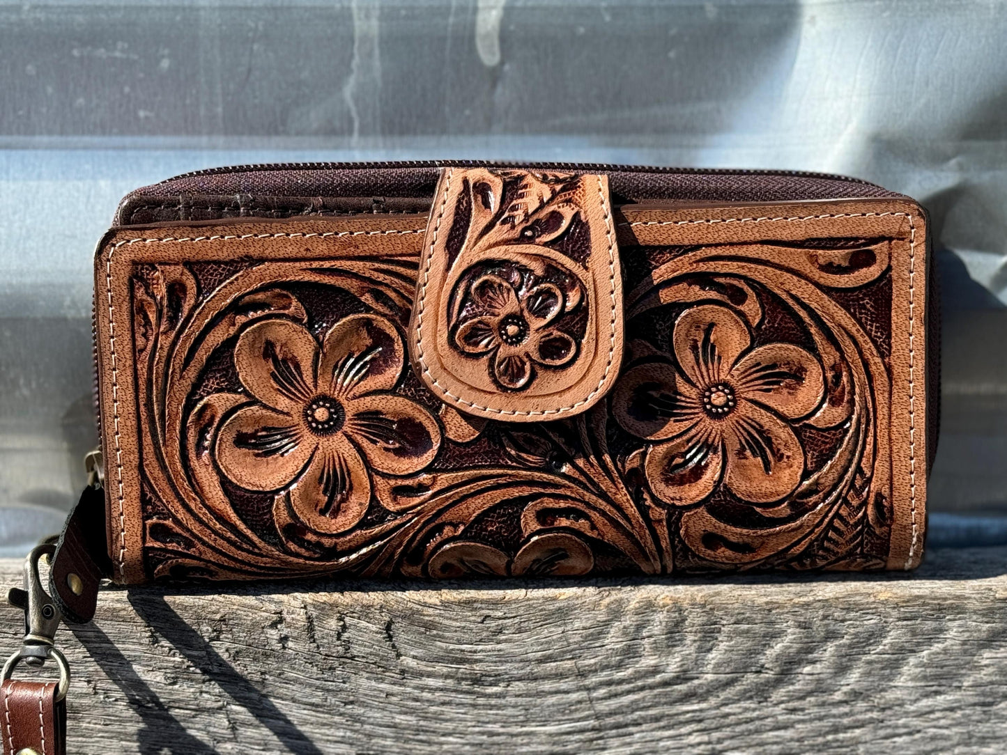 Western wallet with tooled details wristlet strap folding card opening and zipper closure